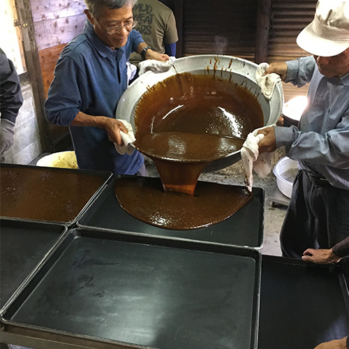 煮詰まったサトウキビ汁をバットにあげます