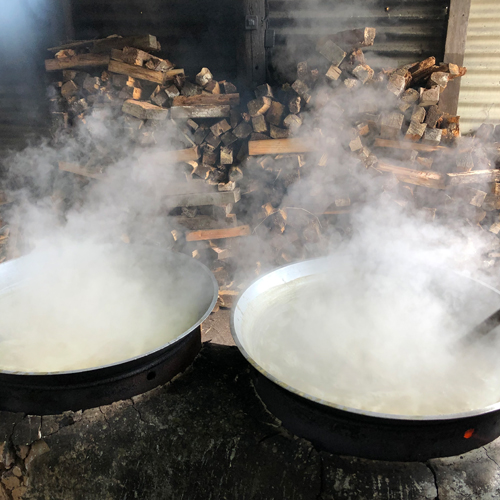 搾ったサトウキビを薪で起こした火で煮詰めていきます。