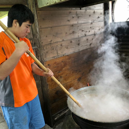 サトウキビの搾り汁をひたすらかきまぜます